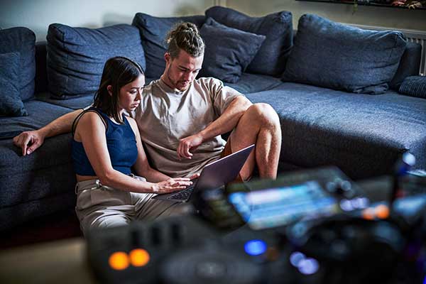 Two young people sitting in front of a laptop.