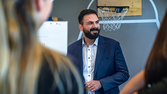 A man in front of a flipchart and basketball hoop