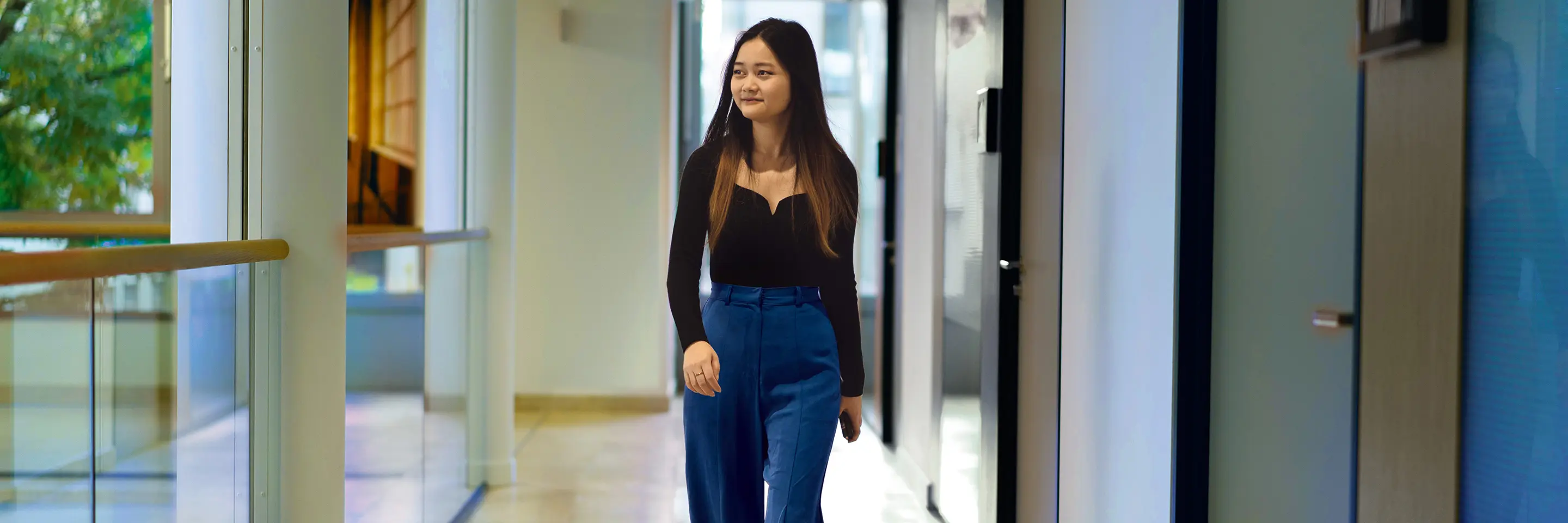 A woman smiles as she walks along the corridor at Aareal Bank