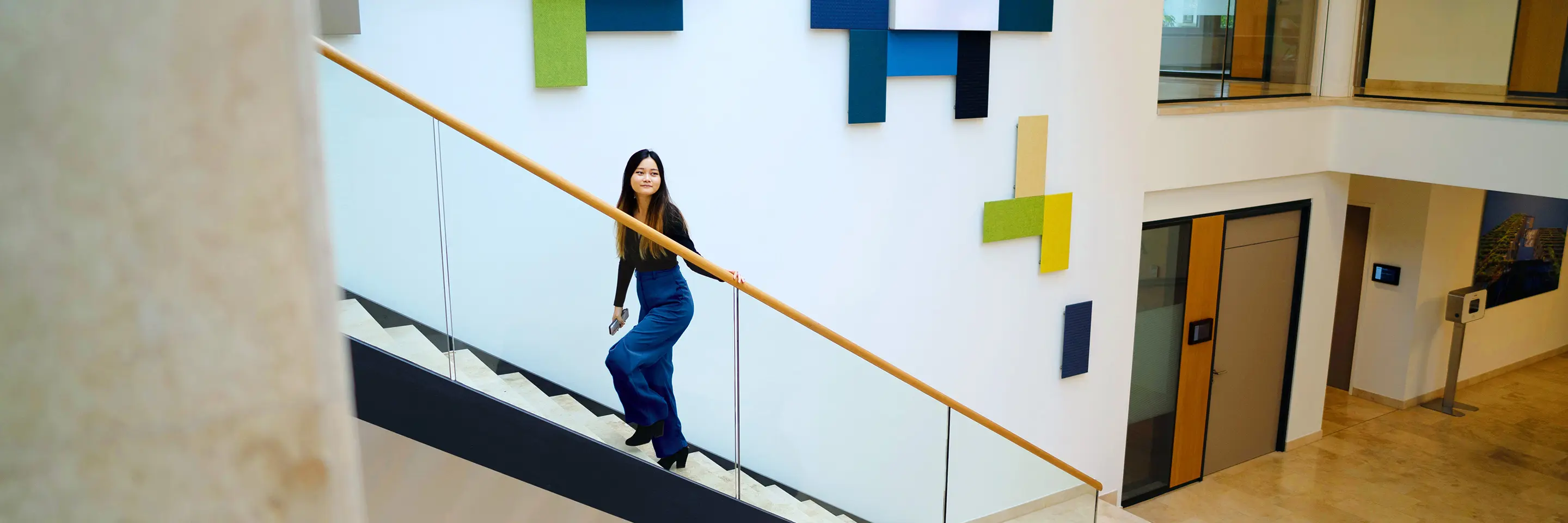 A woman climbs the stairs in the lobby