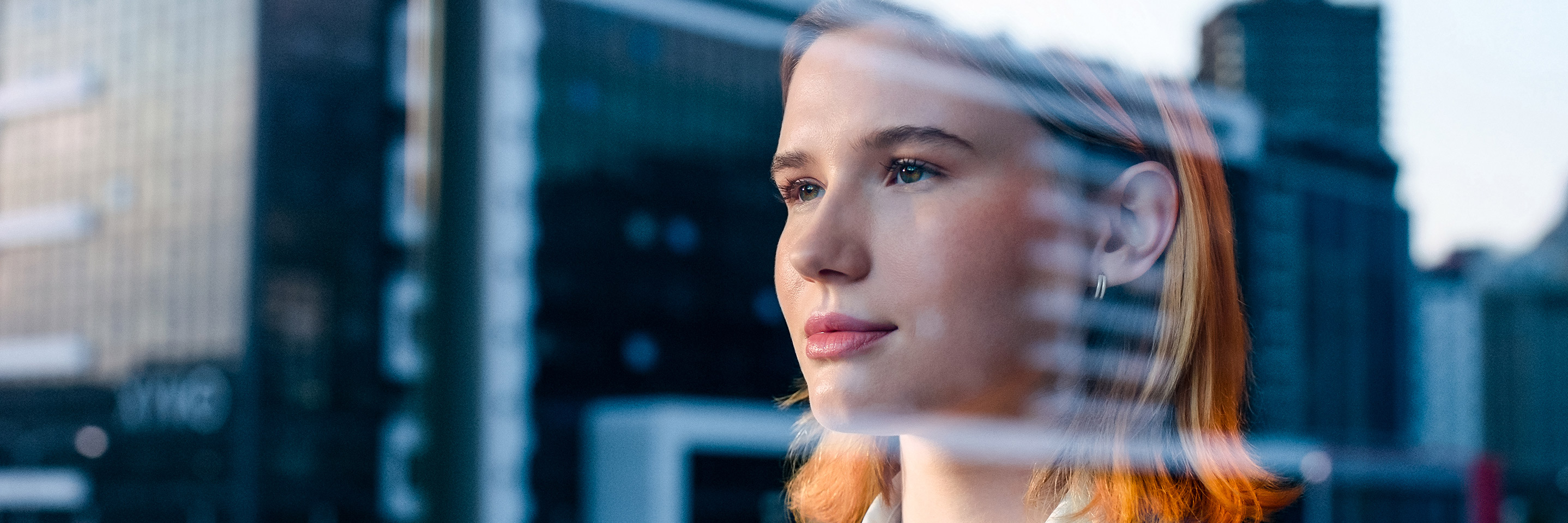 A woman appears to look out of and into a building at the same time.