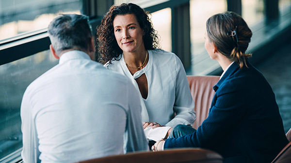 Three people sitting and having a conversation.